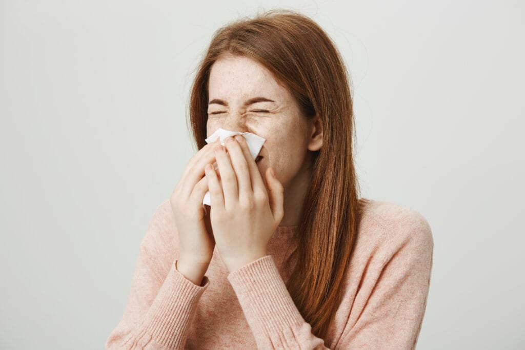 Femme allergique se mouchant