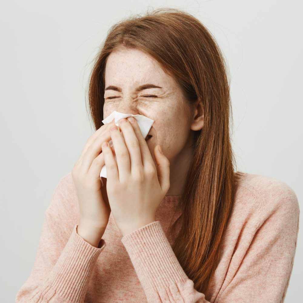Femme allergique se mouchant